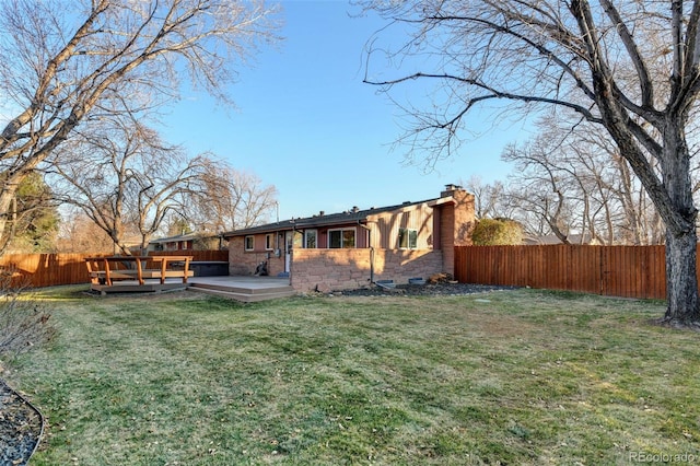 back of house with a lawn and a deck