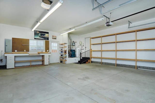 84 Kathy Dr, Buena Vista, CO 81211 - garage featuring a garage door opener, electric panel, water heater, and a workshop area