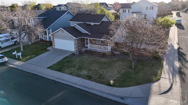 13906 Jackson St, Thornton, CO 80602 - view of front of home featuring stone siding, a residential view, a front yard, driveway, and covered porch