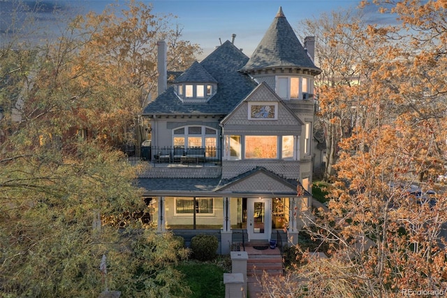 victorian home with a chimney and roof with shingles