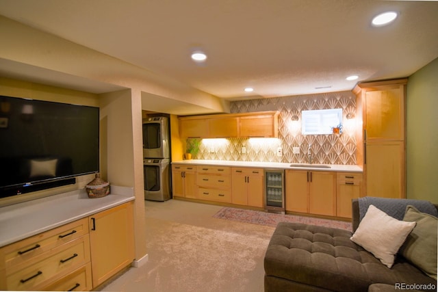 12498 W Prentice Dr, Littleton, CO 80127 - kitchen with beverage cooler, stacked washer and clothes dryer, light countertops, tasteful backsplash, and open floor plan