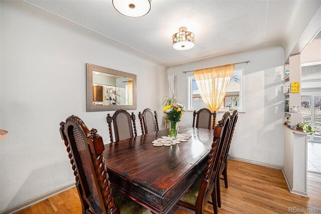 dining area with baseboards and light wood-type flooring