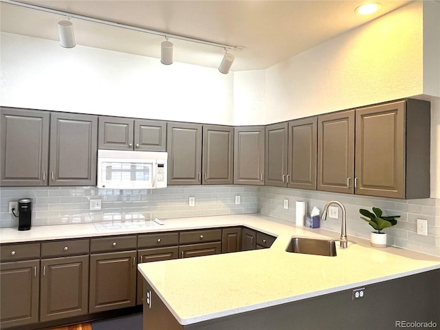 kitchen featuring sink, backsplash, and white appliances