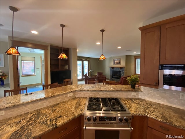1145 S Williams St, Denver, CO 80210 - kitchen featuring a glass covered fireplace, appliances with stainless steel finishes, open floor plan, decorative light fixtures, and recessed lighting