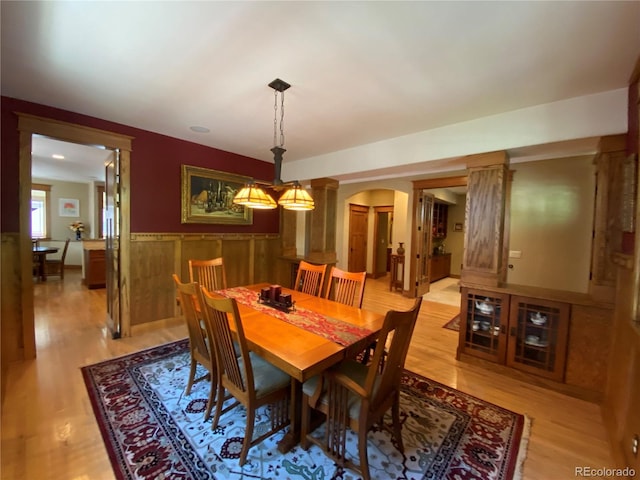 1145 S Williams St, Denver, CO 80210 - dining room with arched walkways, ornate columns, light wood-style floors, and a wainscoted wall