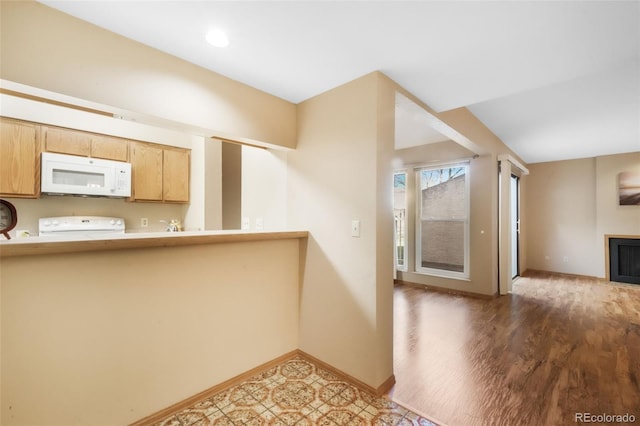 3330 Templeton Gap Rd Unit 15, Colorado Springs, CO 80907 - kitchen with white microwave, baseboards, a fireplace, range, and wood finished floors