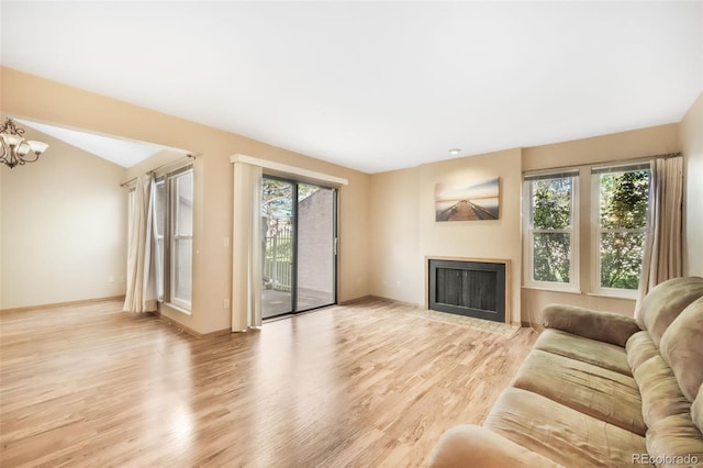3330 Templeton Gap Rd Unit 15, Colorado Springs, CO 80907 - living room with plenty of natural light, a fireplace with flush hearth, light wood-style floors, and a chandelier