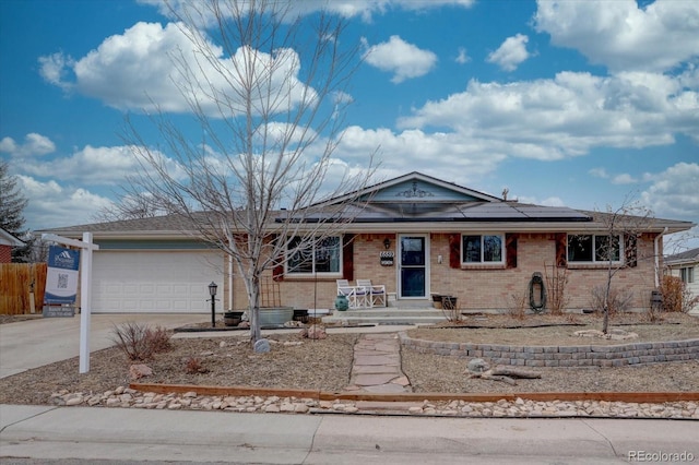 ranch-style home with a garage and solar panels