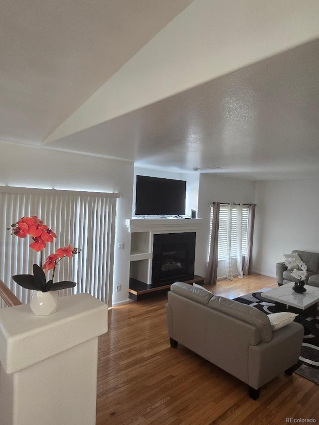 living room featuring dark wood-type flooring and lofted ceiling