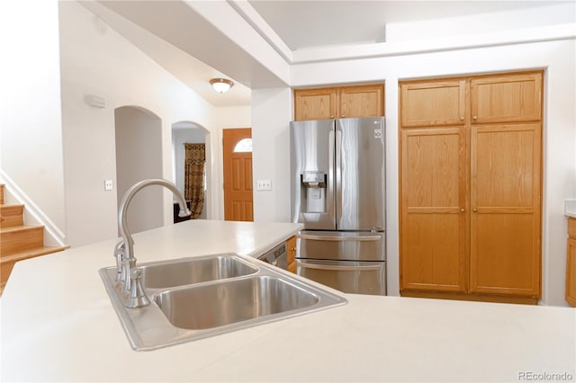 kitchen with sink, lofted ceiling, and stainless steel refrigerator with ice dispenser