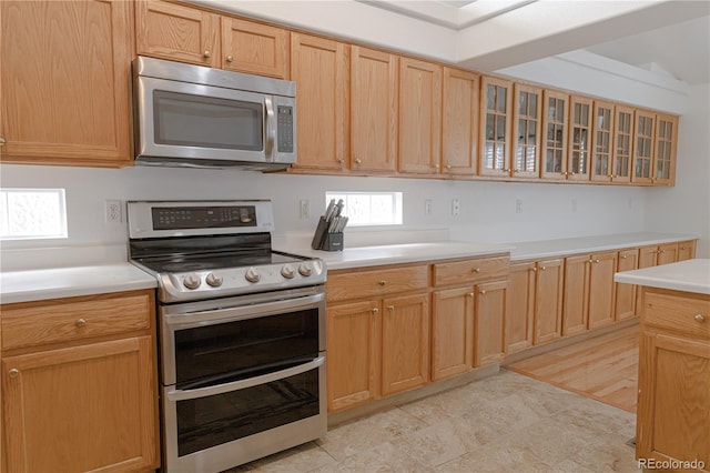 kitchen with light brown cabinetry and appliances with stainless steel finishes