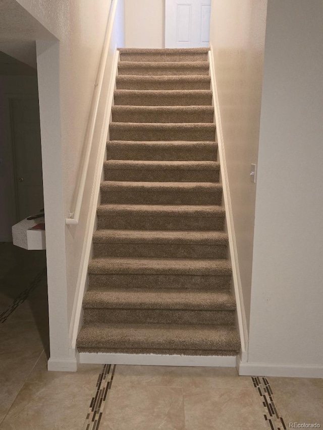 stairway with tile patterned floors