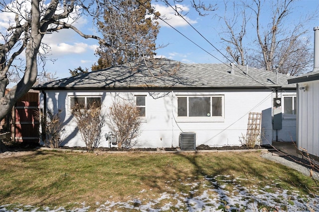 back of property with central AC and a yard