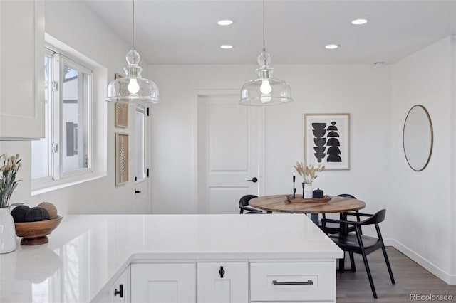 kitchen featuring dark hardwood / wood-style flooring, white cabinetry, and hanging light fixtures