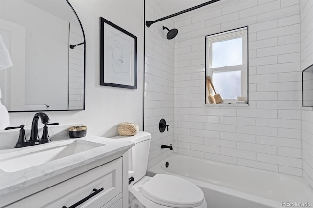 full bathroom with toilet, vanity, and tiled shower / bath