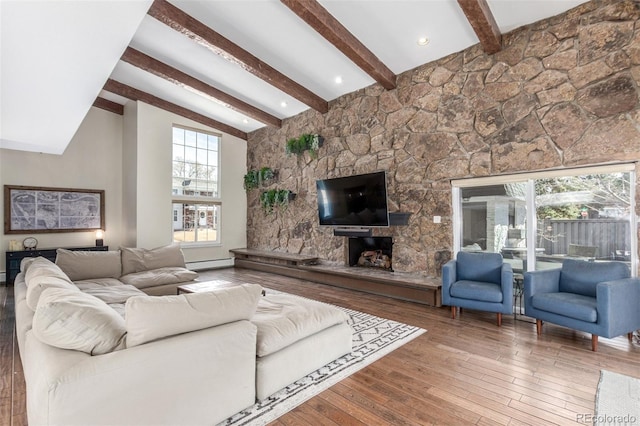 living room featuring hardwood / wood-style floors, high vaulted ceiling, beam ceiling, a fireplace, and baseboard heating