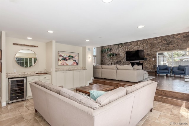 living area with a dry bar, recessed lighting, beverage cooler, and stone tile flooring