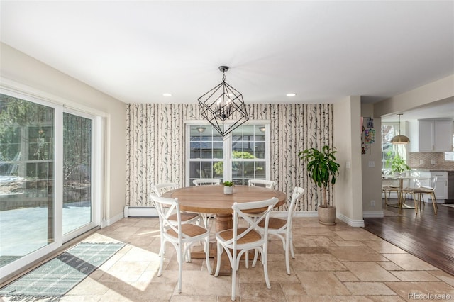 dining room featuring stone tile floors, a chandelier, recessed lighting, and baseboards