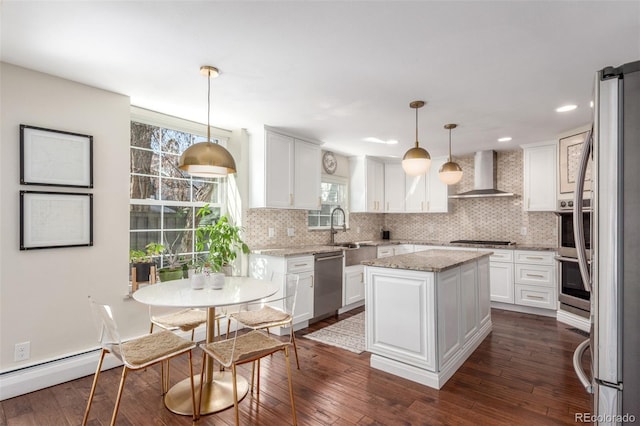 kitchen with stainless steel appliances, white cabinetry, tasteful backsplash, and wall chimney range hood