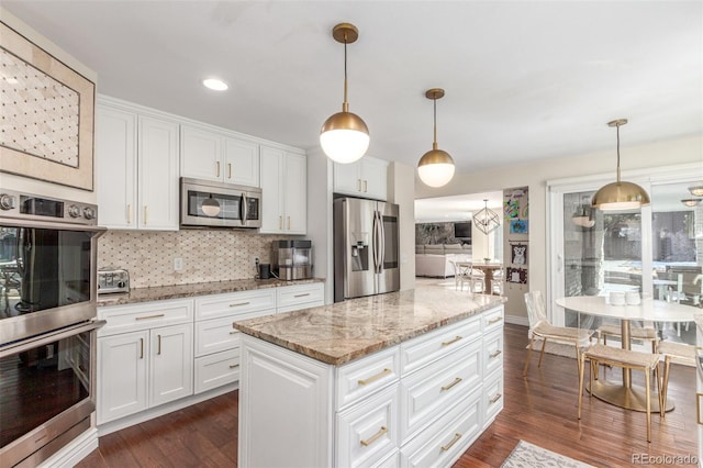 kitchen with dark wood-type flooring, backsplash, white cabinetry, appliances with stainless steel finishes, and light stone countertops