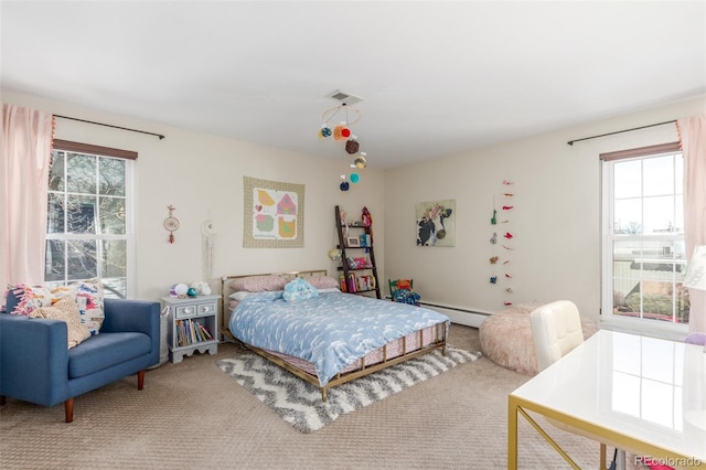 carpeted bedroom featuring a baseboard heating unit and visible vents