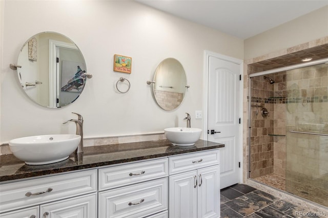 full bathroom featuring a sink, a stall shower, and double vanity