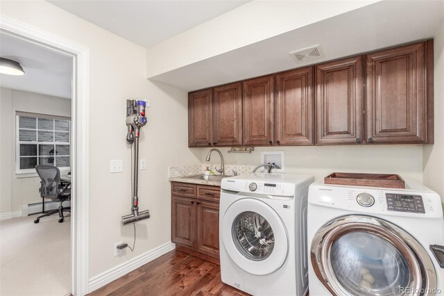 laundry room featuring visible vents, a sink, cabinet space, separate washer and dryer, and baseboard heating