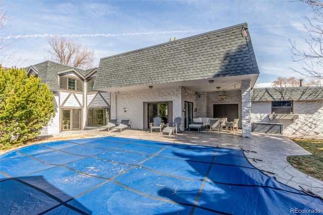 view of pool featuring a covered pool, a patio, and an outdoor hangout area