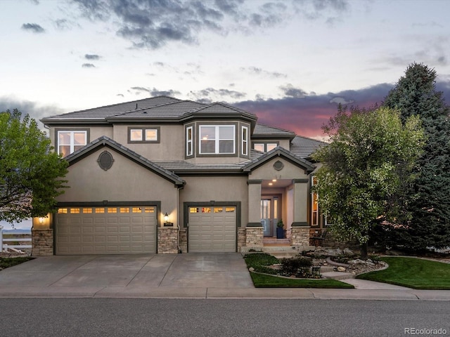 10531 Lieter Pl, Lone Tree, CO 80124 - view of front facade with stone siding, a garage, concrete driveway, stucco siding, and a tile roof