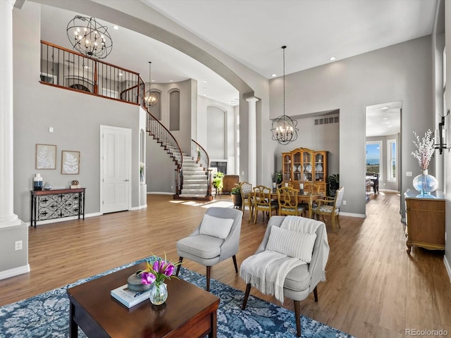 10531 Lieter Pl, Lone Tree, CO 80124 - living area with a high ceiling, a chandelier, decorative columns, baseboards, and wood finished floors