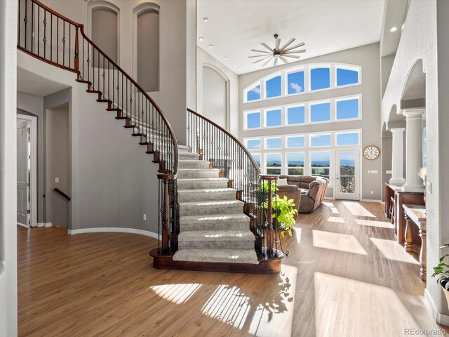 10531 Lieter Pl, Lone Tree, CO 80124 - entryway featuring a high ceiling, baseboards, decorative columns, wood finished floors, and stairs