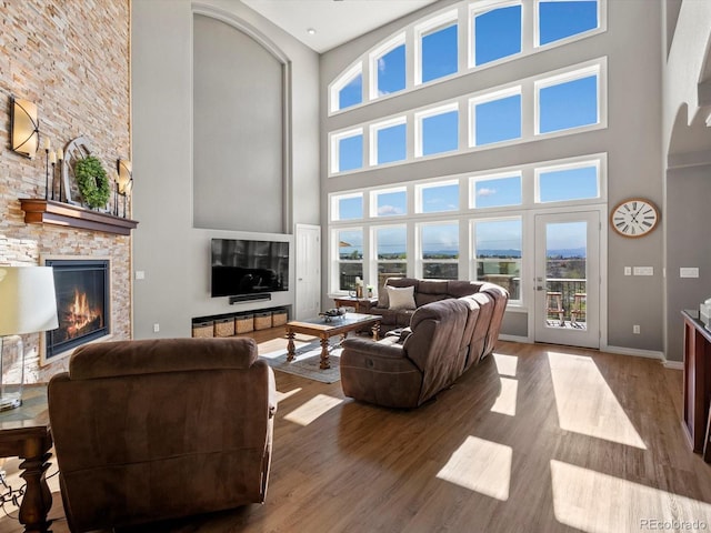 10531 Lieter Pl, Lone Tree, CO 80124 - living room with a high ceiling, wood finished floors, healthy amount of natural light, a fireplace, and baseboards
