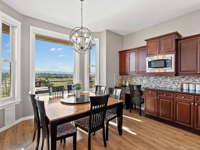 10531 Lieter Pl, Lone Tree, CO 80124 - dining space with a chandelier, plenty of natural light, light wood finished floors, and baseboards