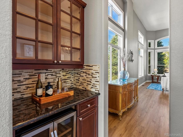 10531 Lieter Pl, Lone Tree, CO 80124 - indoor dry bar with light wood-style floors, tasteful backsplash, wine cooler, and a textured wall