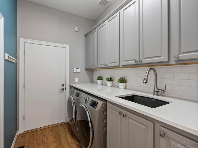10531 Lieter Pl, Lone Tree, CO 80124 - laundry room featuring washer and clothes dryer, cabinet space, and wood finished floors