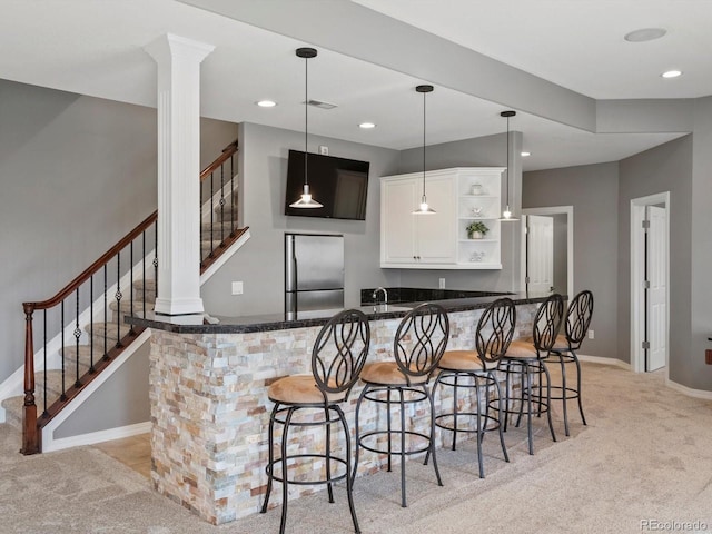 10531 Lieter Pl, Lone Tree, CO 80124 - kitchen with stainless steel fridge, open shelves, light carpet, white cabinets, and a kitchen breakfast bar