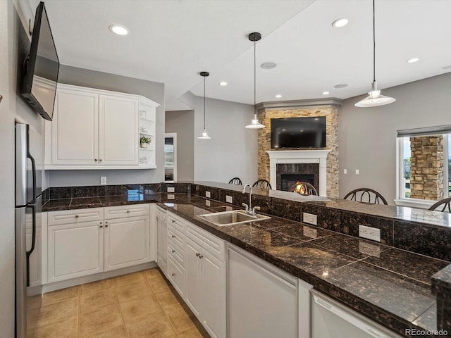 10531 Lieter Pl, Lone Tree, CO 80124 - kitchen with a sink, white cabinetry, a lit fireplace, freestanding refrigerator, and decorative light fixtures