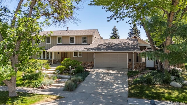 4398 Carter Trl, Boulder, CO 80301 - view of front facade with an attached garage, stone siding, driveway, and a shingled roof