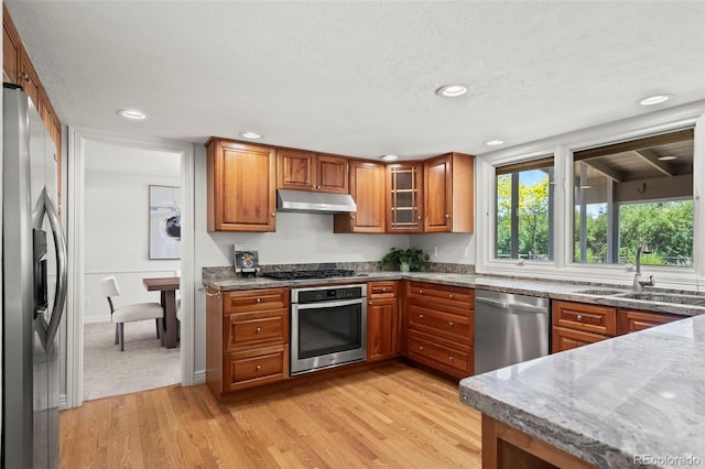 4398 Carter Trl, Boulder, CO 80301 - kitchen featuring appliances with stainless steel finishes, under cabinet range hood, brown cabinetry, recessed lighting, and a textured ceiling