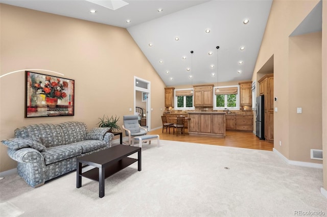 4398 Carter Trl, Boulder, CO 80301 - living area with high vaulted ceiling, a skylight, light carpet, recessed lighting, and light wood finished floors