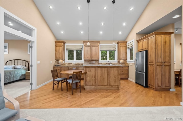 4398 Carter Trl, Boulder, CO 80301 - kitchen featuring freestanding refrigerator, light wood-style flooring, a center island, decorative light fixtures, and tasteful backsplash