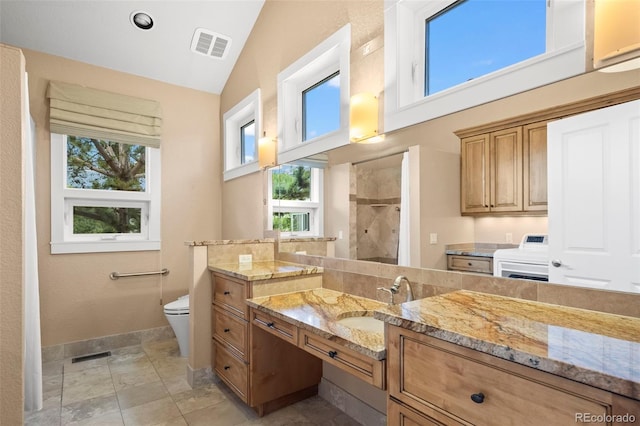 4398 Carter Trl, Boulder, CO 80301 - bathroom featuring a tile shower, washer / dryer, vanity, and lofted ceiling