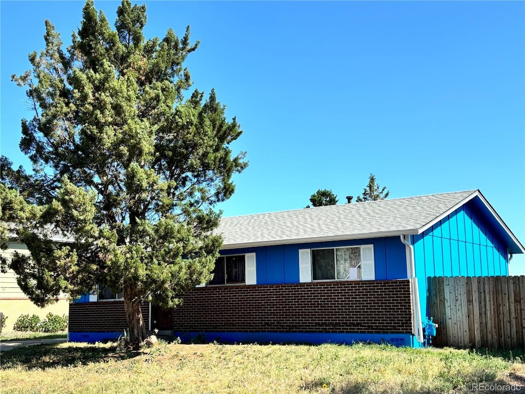 14832 Elmendorf Pl, Denver, CO 80239 - view of front facade featuring brick siding and roof with shingles