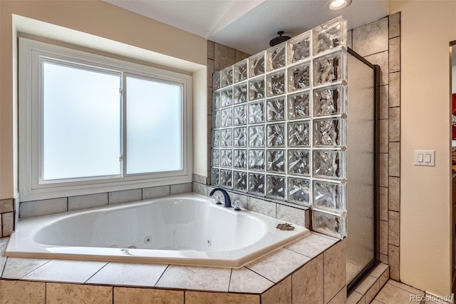 bathroom with a tile shower, a whirlpool tub, and tile patterned flooring