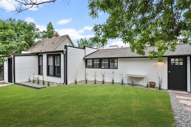 view of front of property with a front lawn and roof with shingles