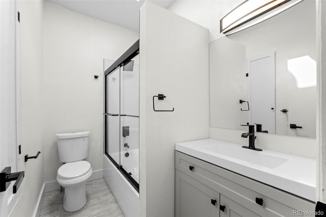 bathroom with shower / bath combination with glass door, vanity, toilet, and baseboards