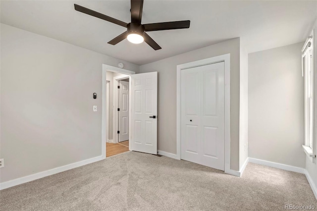 unfurnished bedroom with a ceiling fan, carpet, a closet, and baseboards