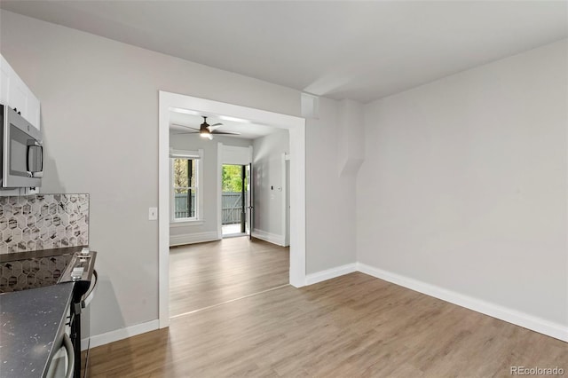 unfurnished dining area with light wood-type flooring and baseboards