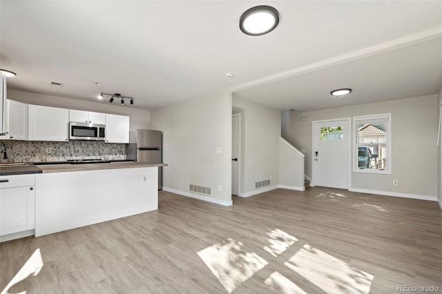 kitchen with dark countertops, white cabinetry, visible vents, and stainless steel appliances