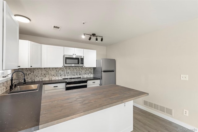 kitchen with visible vents, appliances with stainless steel finishes, decorative backsplash, and a sink